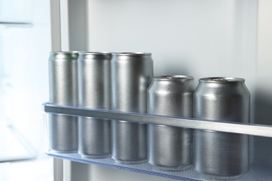 Many cans of beer in refrigerator, closeup