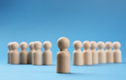 Photo of Loneliness concept. Human figure distant from others on blue background