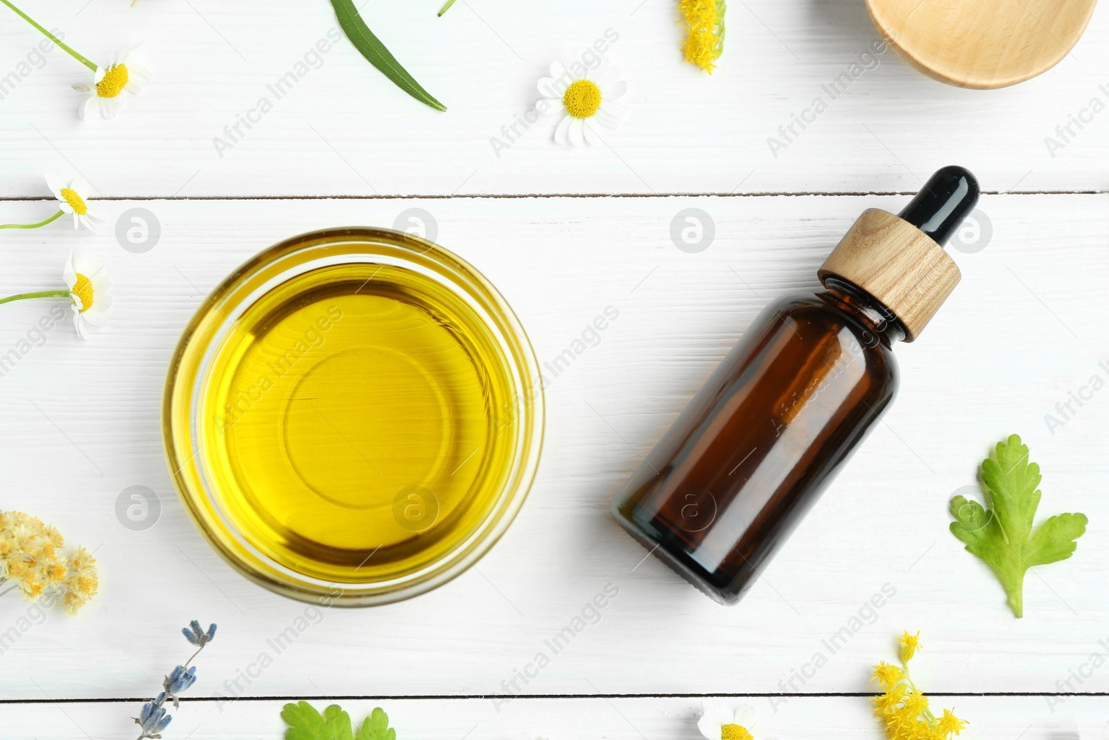 Photo of Tinctures and medicinal herbs on white wooden table, flat lay