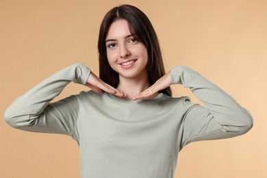 Portrait of cute teenage girl on beige background