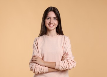 Photo of Portrait of cute teenage girl on beige background. Space for text