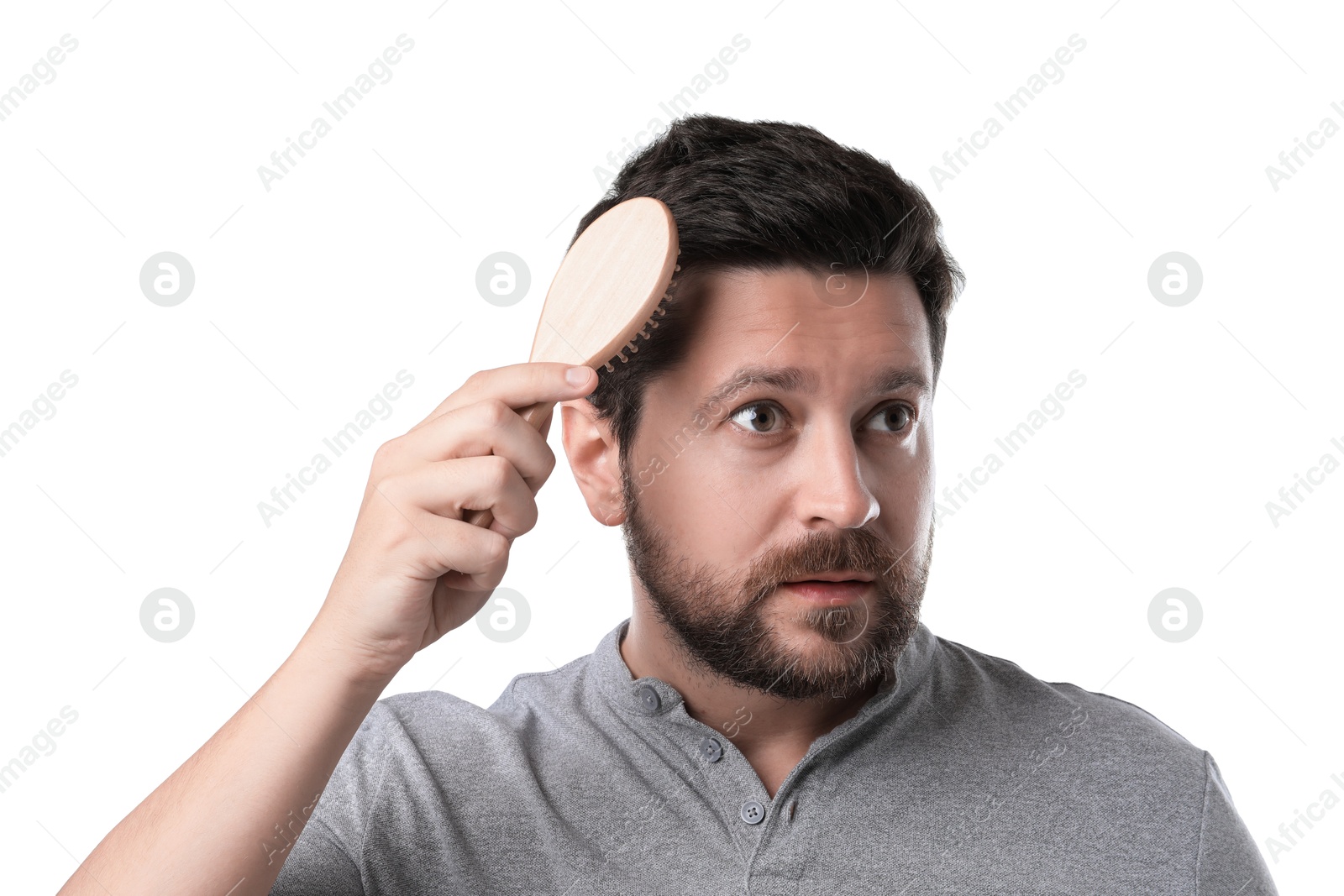 Photo of Man brushing his hair on white background. Alopecia problem