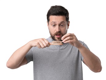 Photo of Hair loss problem. Shocked man with brush on white background