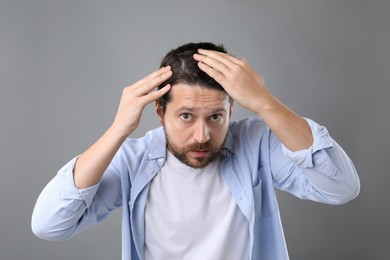 Photo of Man with hair loss problem on gray background