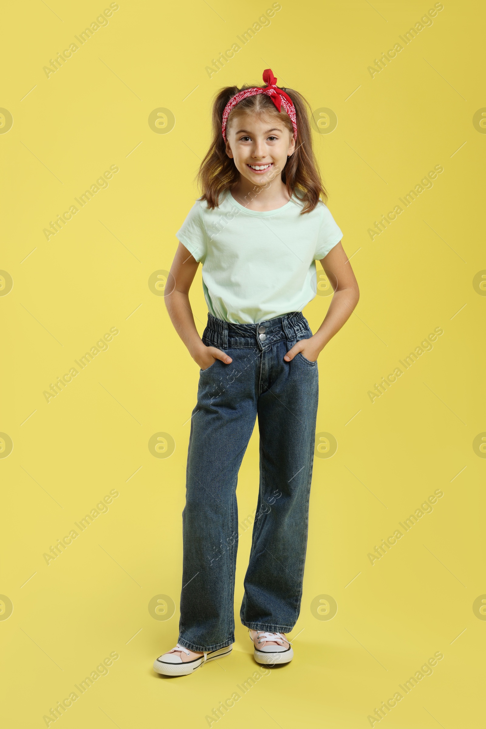 Photo of Full length portrait of cute girl on yellow background