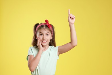 Portrait of cute girl on yellow background