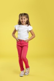 Photo of Full length portrait of cute girl on yellow background