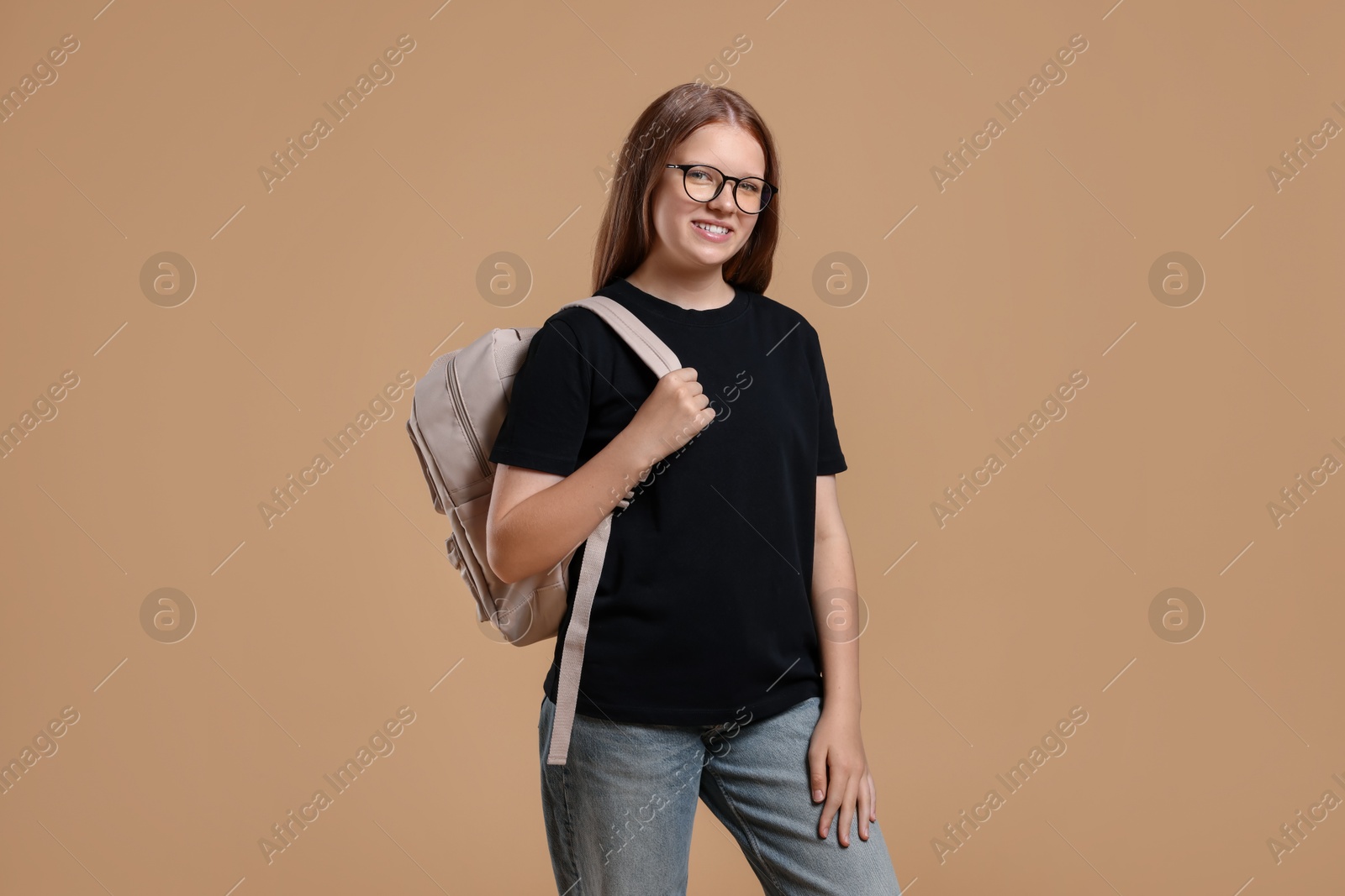 Photo of Teenage girl with backpack on beige background