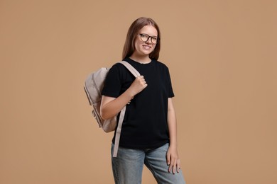 Photo of Teenage girl with backpack on beige background