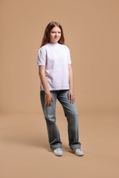 Full length portrait of teenage girl on beige background