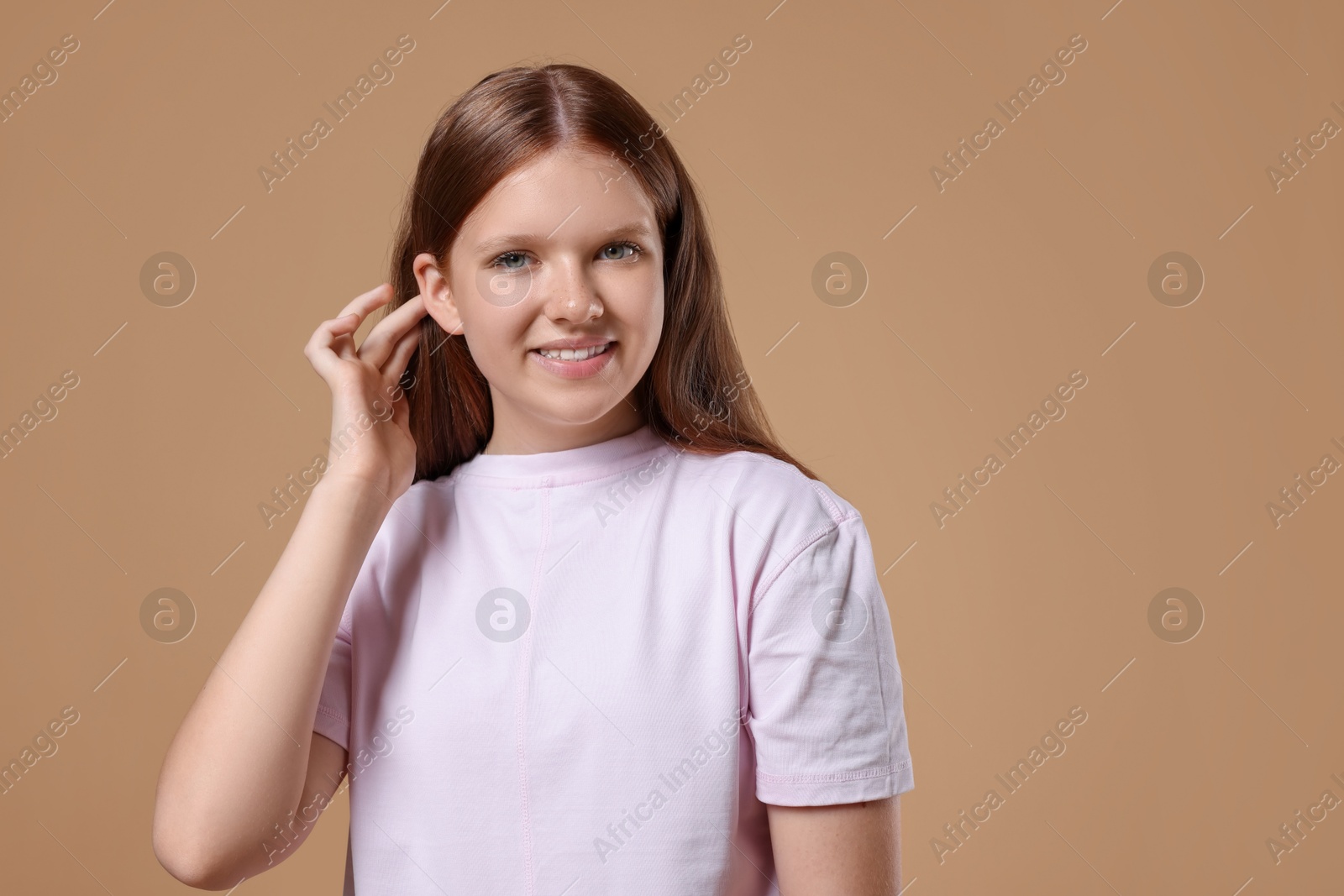 Photo of Portrait of teenage girl on beige background, space for text