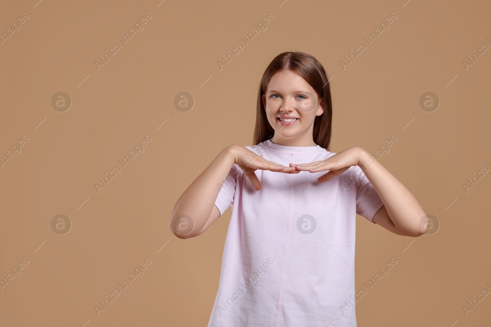 Photo of Portrait of teenage girl on beige background, space for text