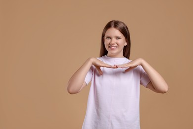 Portrait of teenage girl on beige background, space for text