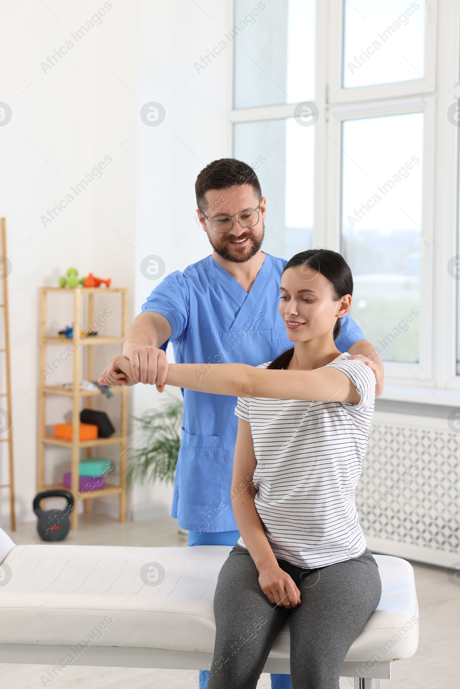 Photo of Physiotherapist working with patient in rehabilitation center