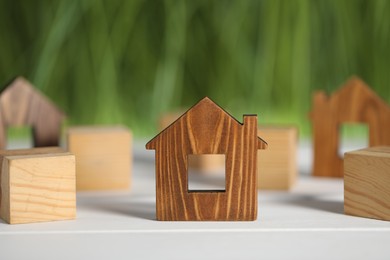 Photo of House hunting. House figure on white wooden table