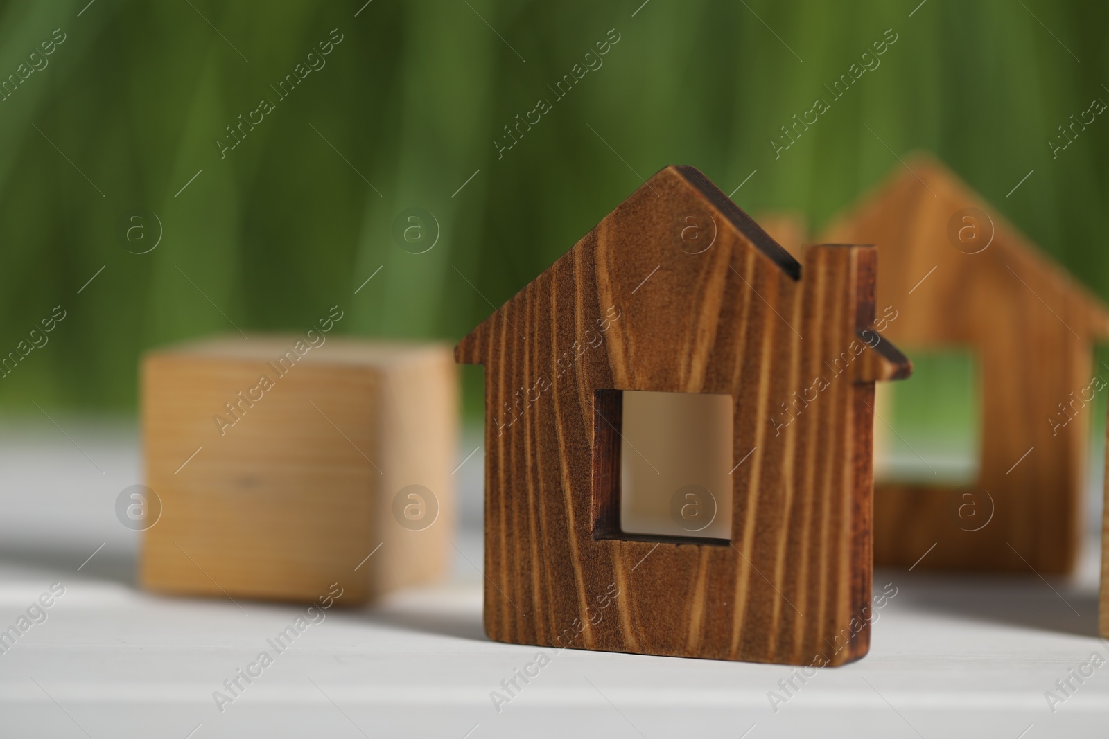 Photo of House hunting. House figure on white wooden table