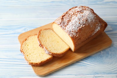 Photo of Freshly baked sponge cake on light blue wooden table