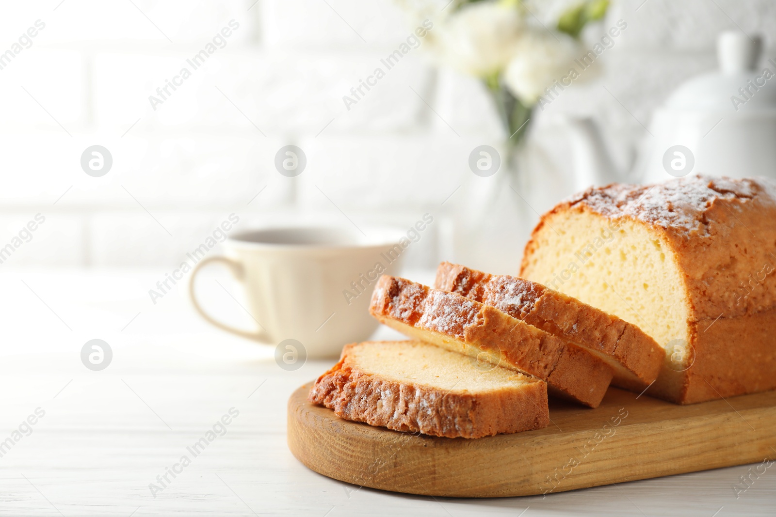 Photo of Freshly baked sponge cake on white wooden table, closeup. Space for text