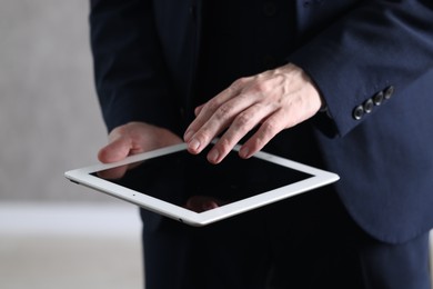 Photo of Businessman using tablet indoors, closeup. Modern technology