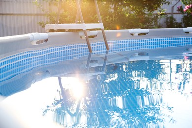 Above ground swimming pool in garden on sunny day, closeup