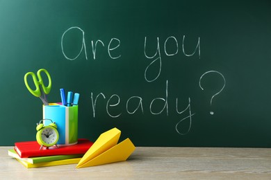 Chalkboard with question Are You Ready and stationery on wooden desk