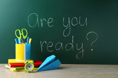 Photo of Chalkboard with question Are You Ready and stationery on wooden desk