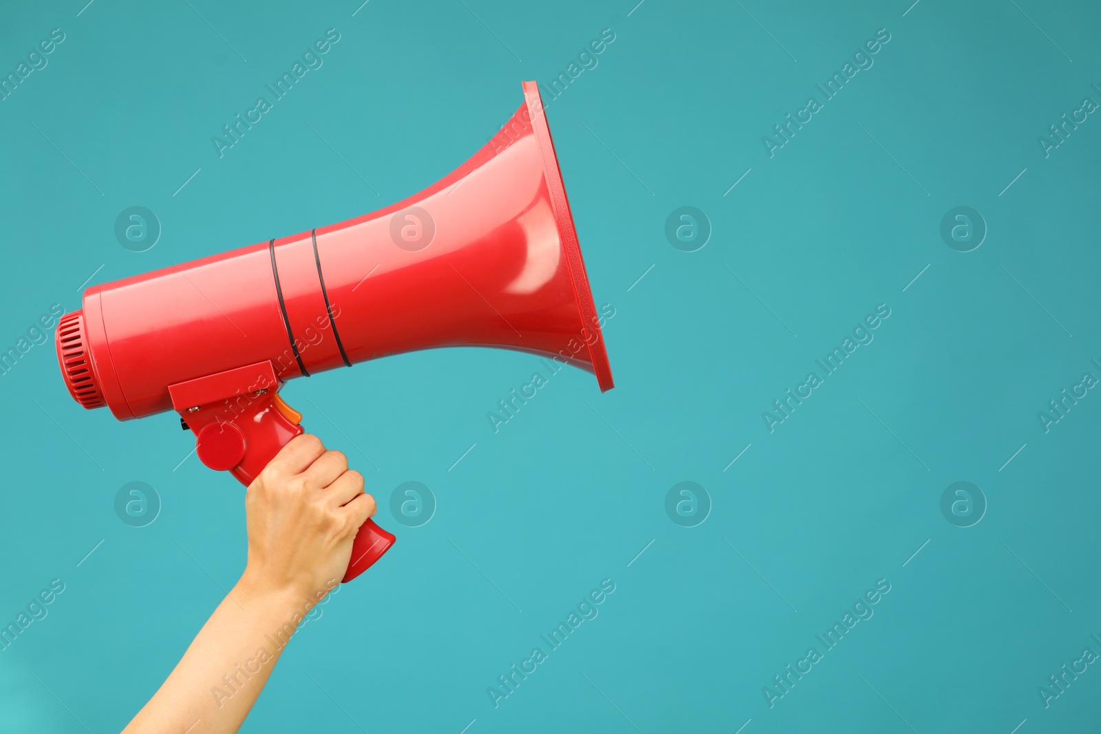 Photo of Woman holding megaphone speaker on blue background, closeup. Space for text