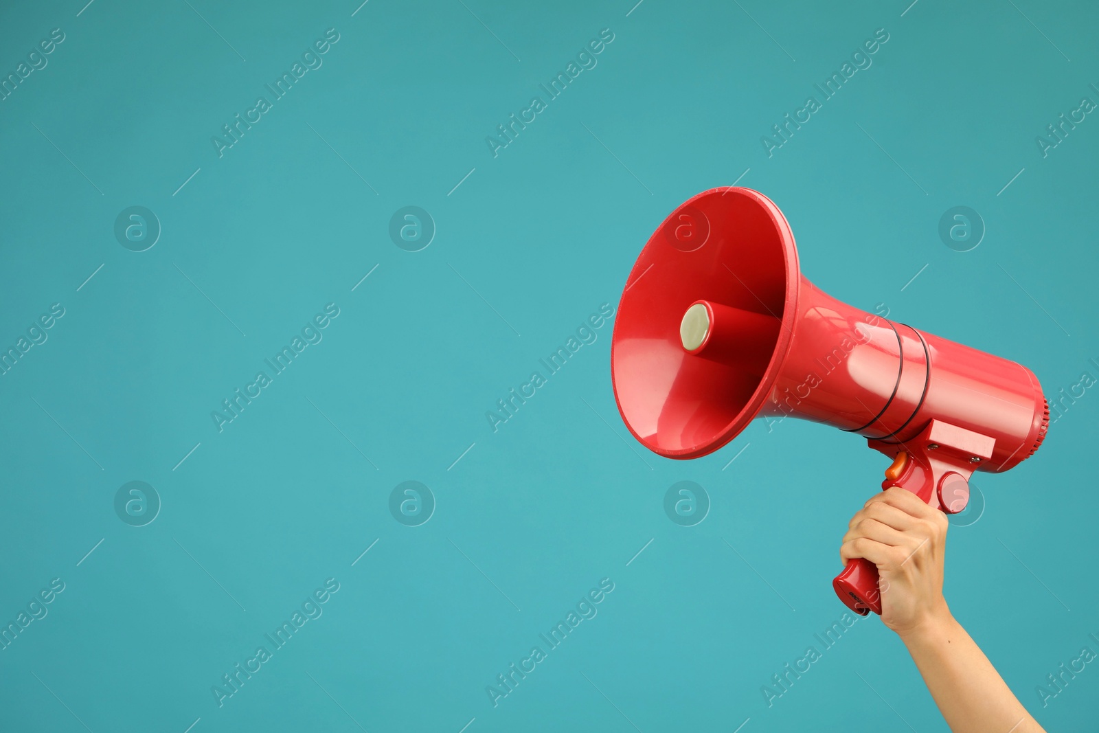 Photo of Woman holding megaphone speaker on blue background, closeup. Space for text