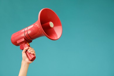 Photo of Woman holding megaphone speaker on blue background, closeup. Space for text