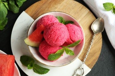 Photo of Scoops of tasty watermelon sorbet with mint, fresh fruit and spoon on grey textured table, flat lay