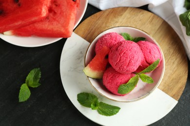 Photo of Scoops of tasty watermelon sorbet with mint and fresh fruit on grey textured table, flat lay