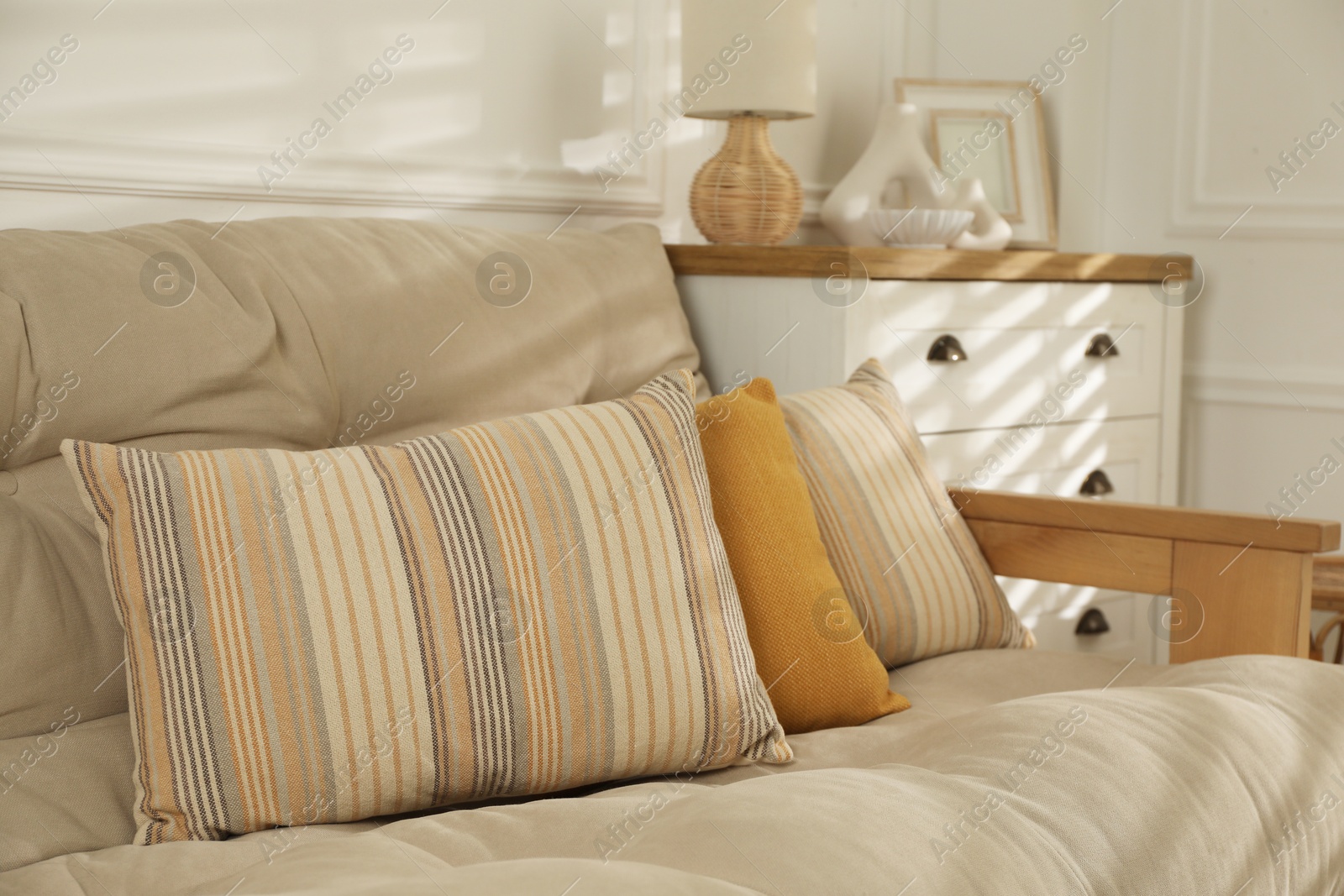 Photo of Soft colorful pillows on sofa at home