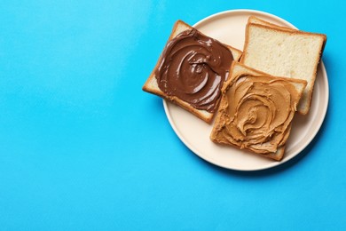 Photo of Delicious sandwiches with peanut butter and chocolate paste on light blue table, top view. Space for text