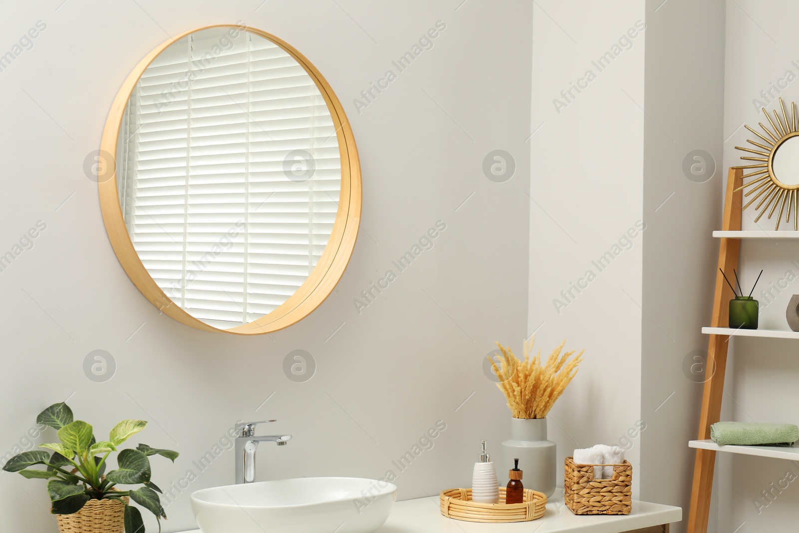 Photo of Round mirror over sink in bathroom. Interior design