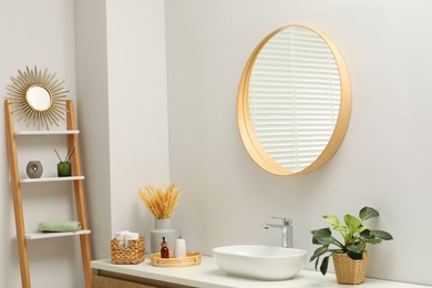 Photo of Round mirror over sink in bathroom. Interior design