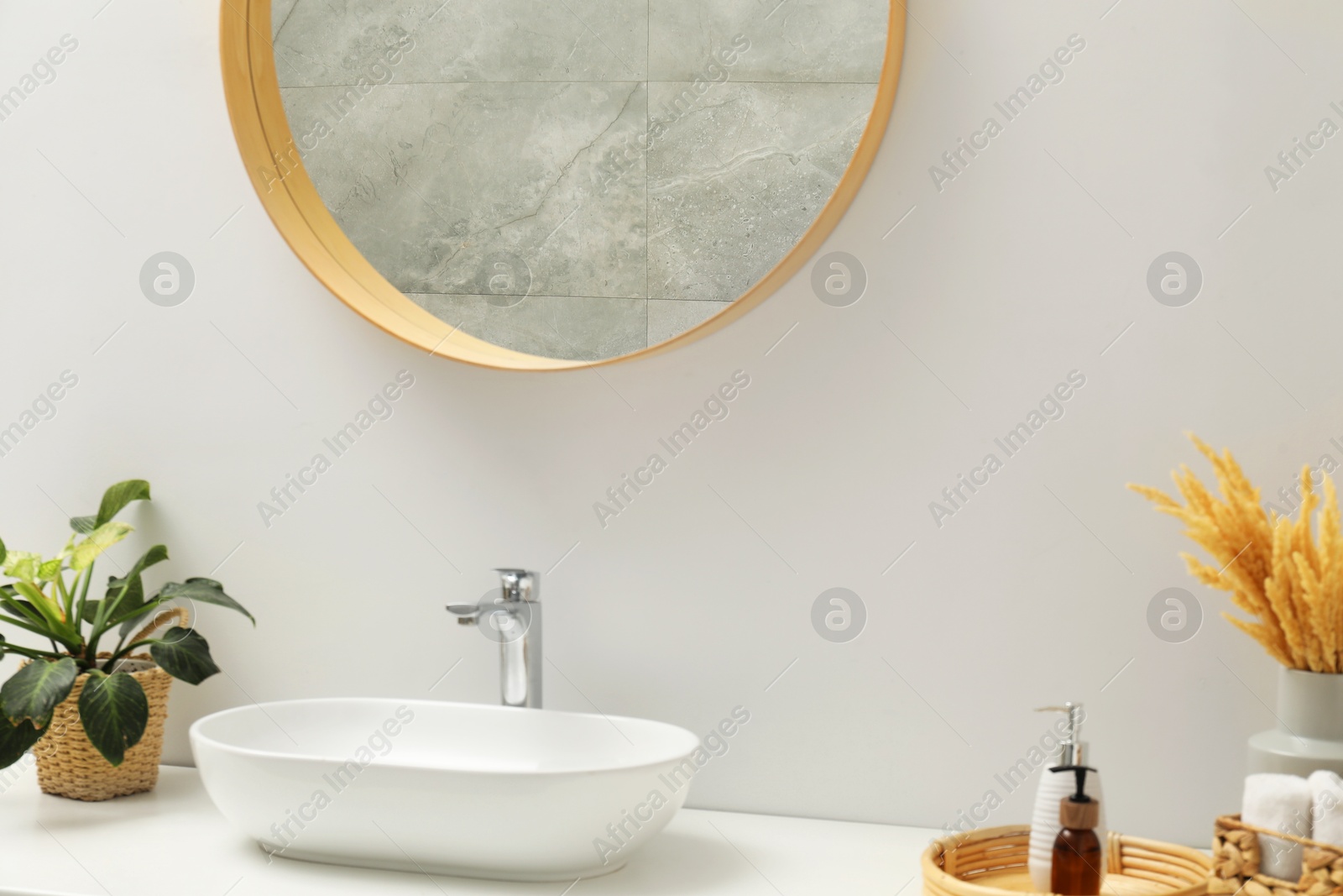 Photo of Round mirror over sink in bathroom. Interior design