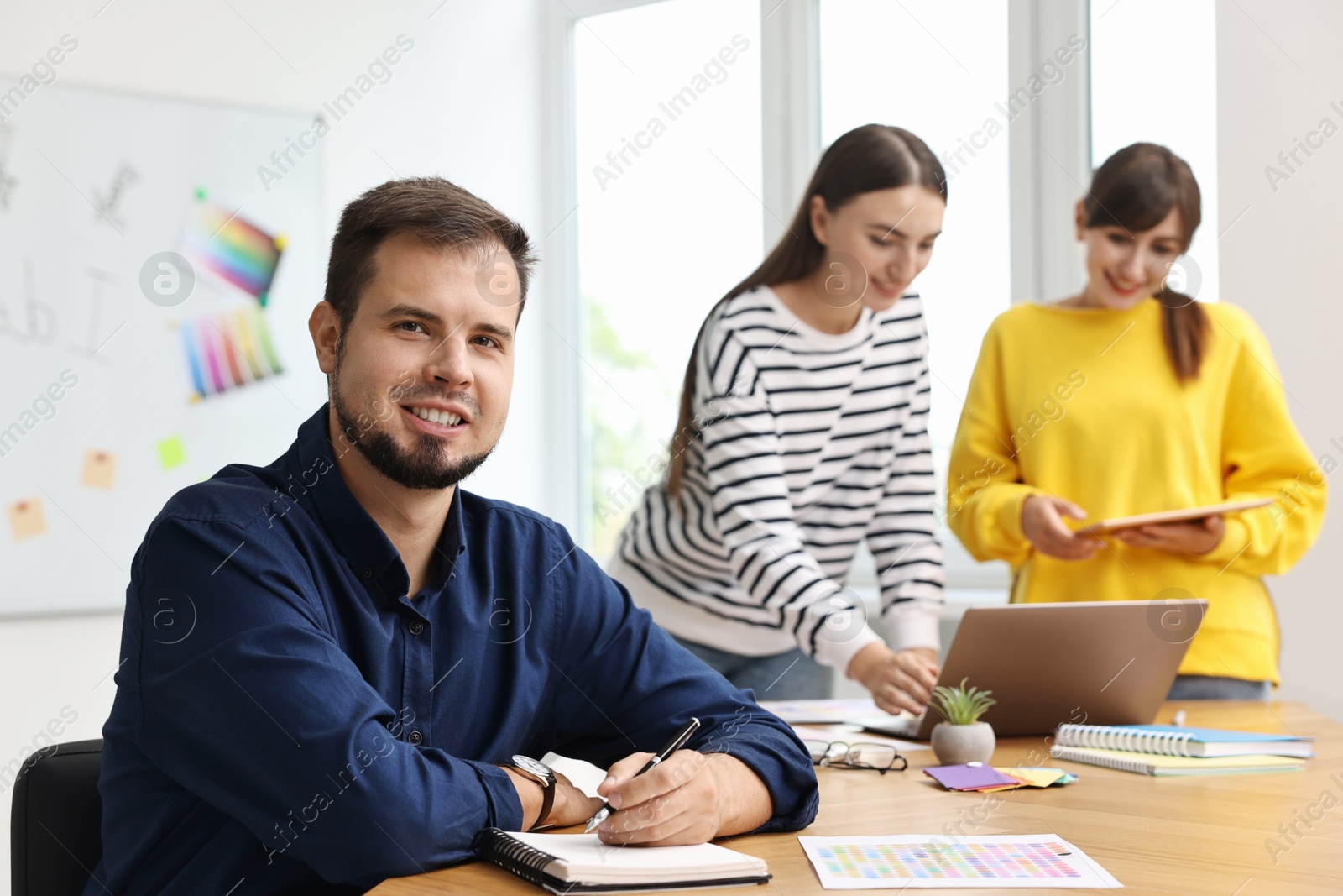 Photo of Portrait of happy young designer in office