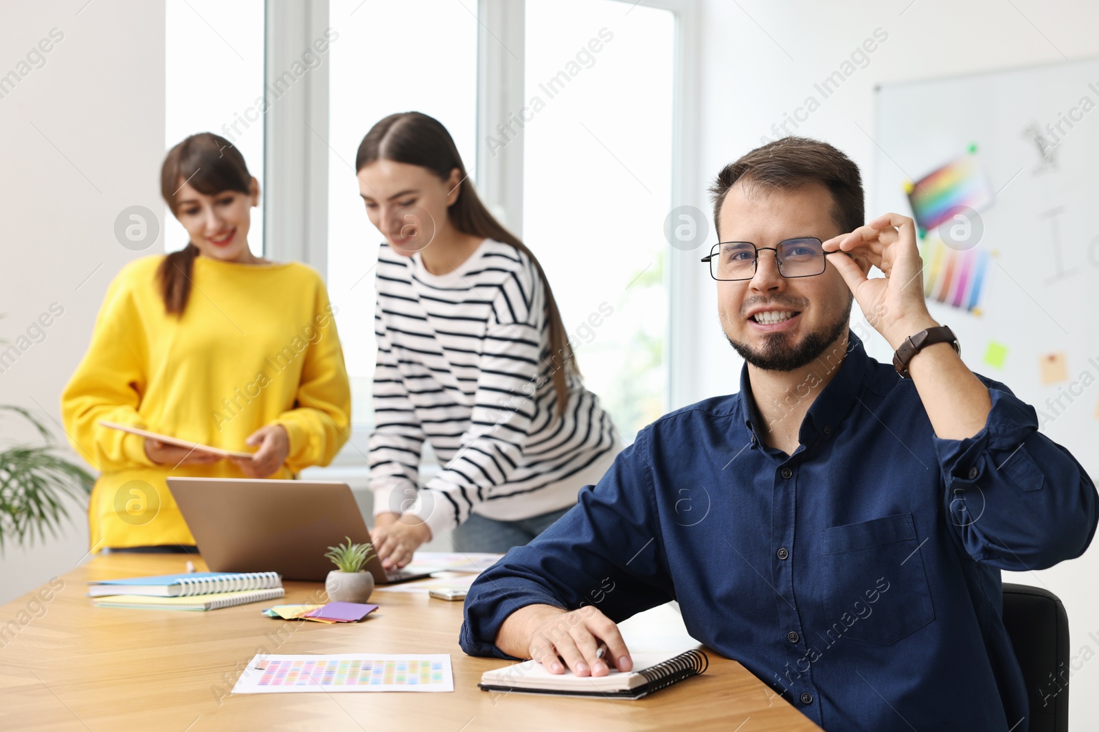 Photo of Portrait of happy young designer in office