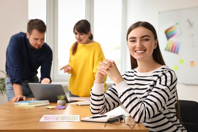 Photo of Portrait of happy young designer in office