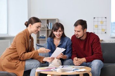 Designer discussing project with clients at table in office