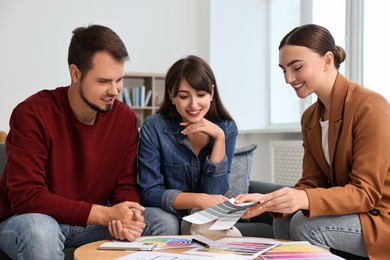 Photo of Designer discussing project with clients at table in office