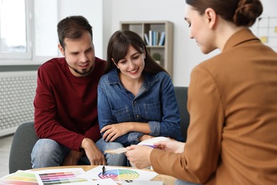 Designer discussing project with clients at table in office