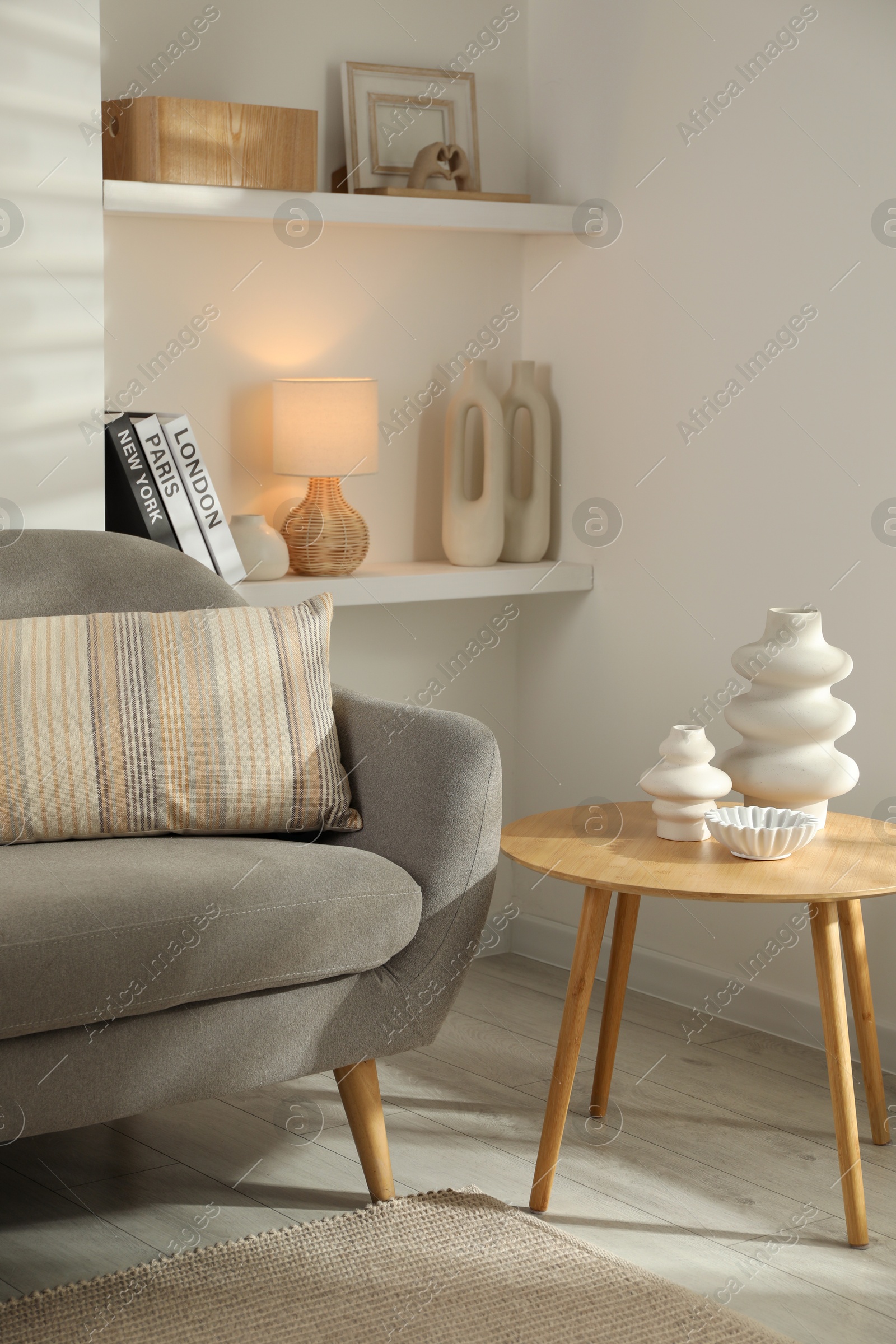 Photo of Sofa with soft cushion and coffee table in living room. Interior design