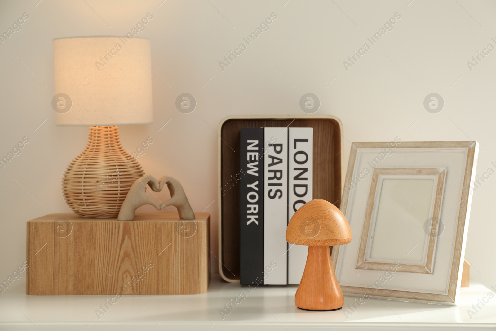 Photo of Beautiful decorative elements, books and lamp on white table