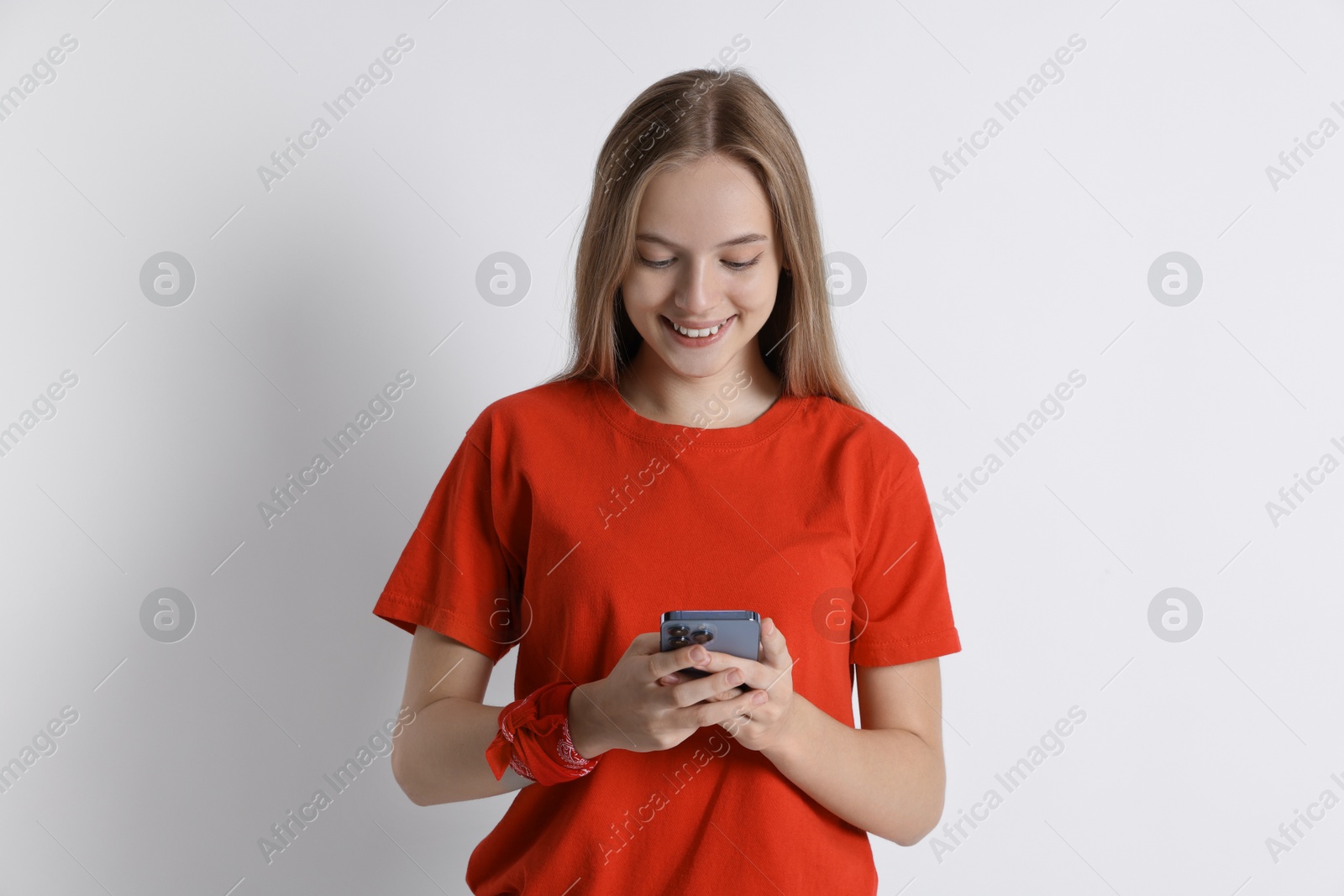 Photo of Teenage girl using smartphone on white background