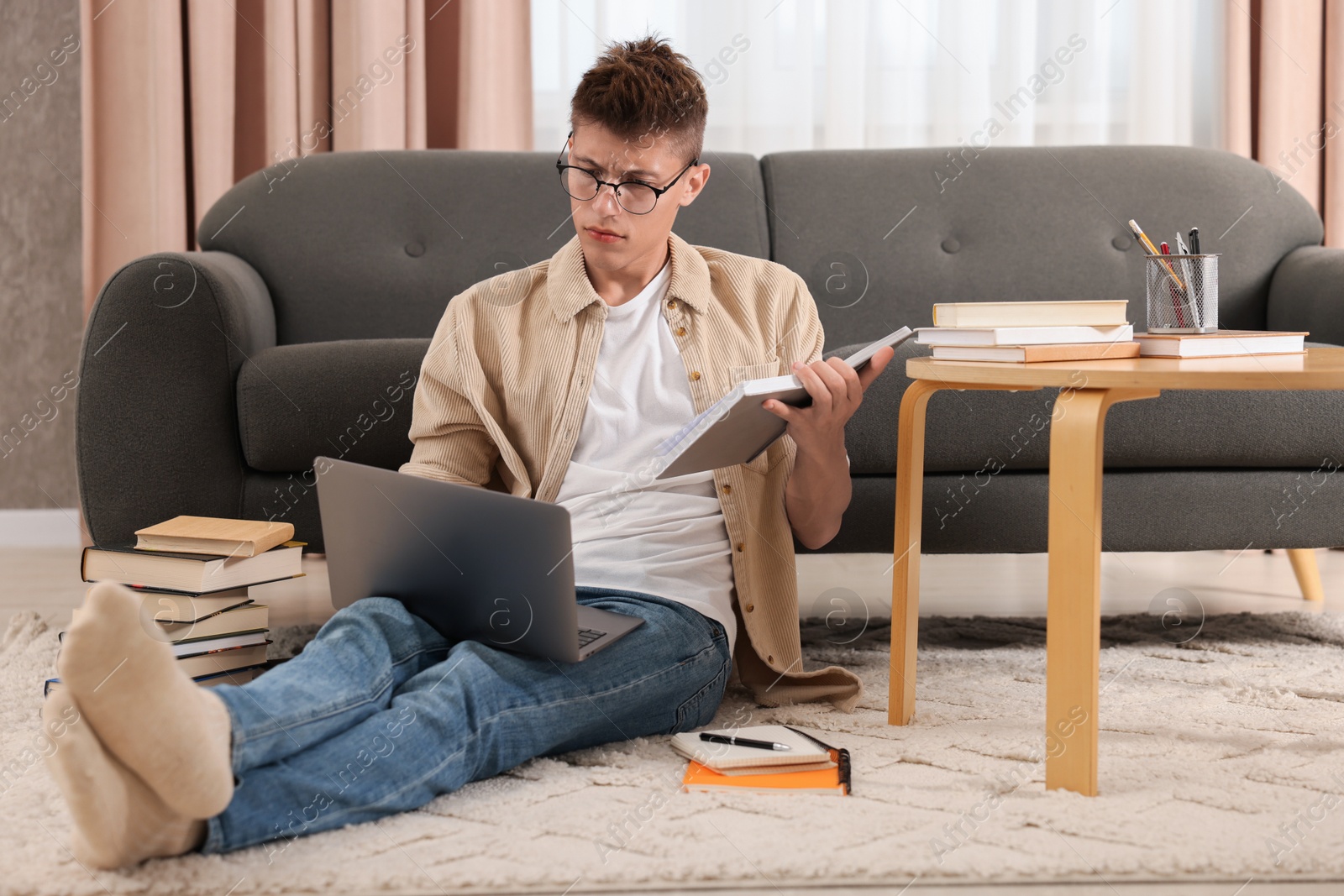 Photo of Student studying with laptop on floor at home