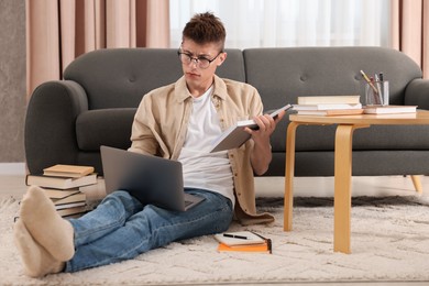 Student studying with laptop on floor at home