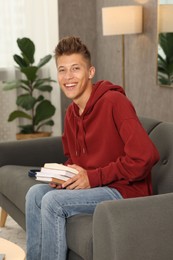 Photo of Student with books studying on sofa at home