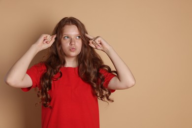 Cute teenage girl gesturing on beige background. Space for text