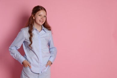 Happy teenage girl posing on pink background. Space for text